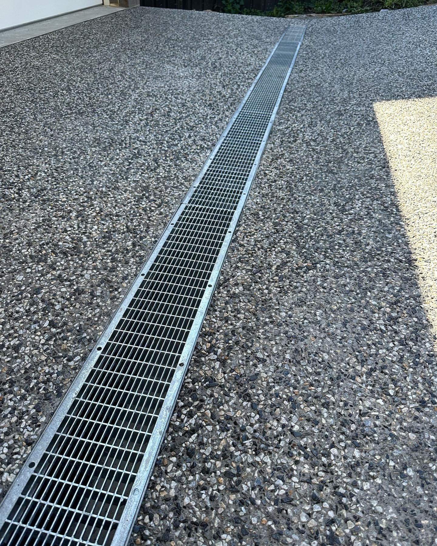 Strip drain set into the exposed aggregate