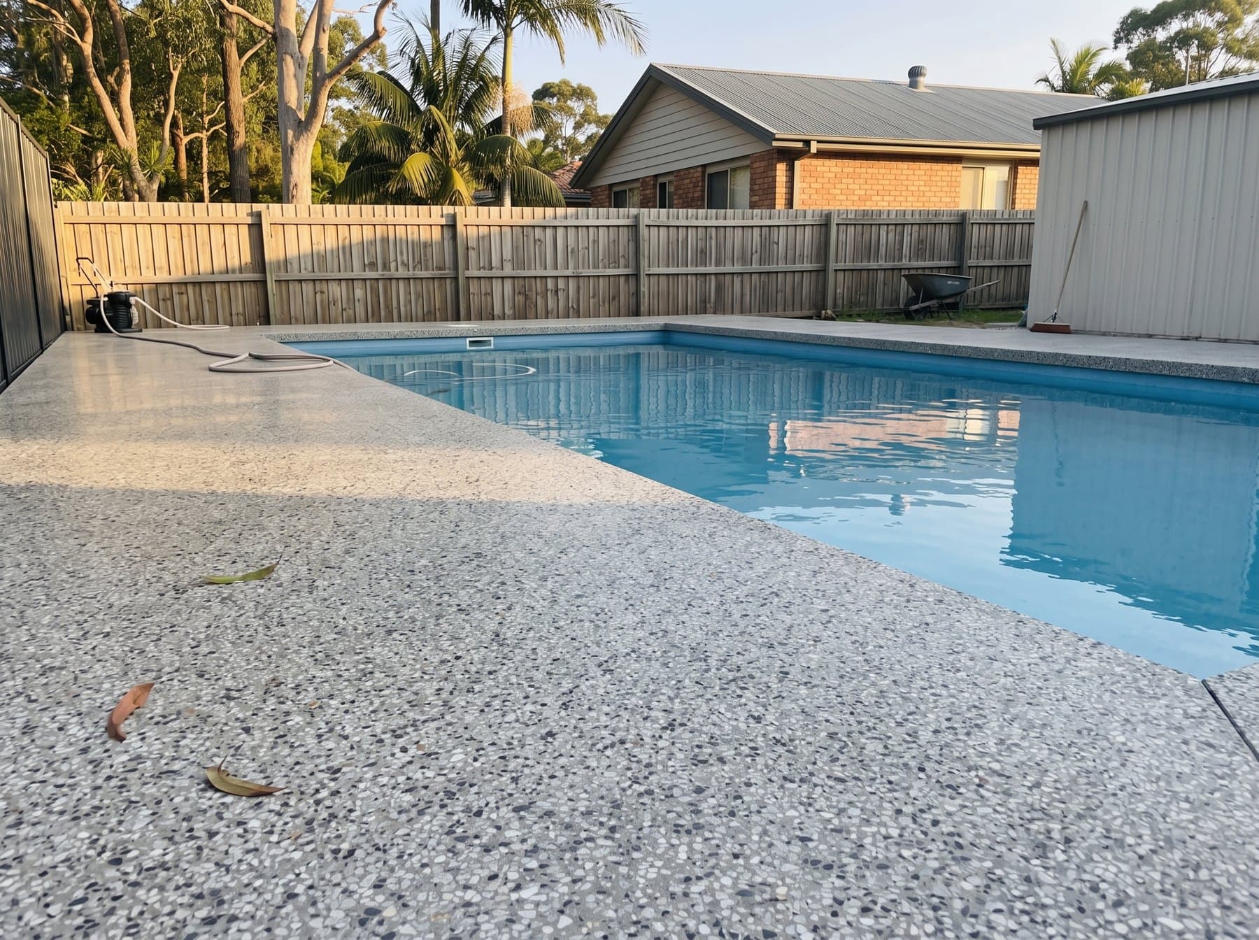 Circular pool with a honed concrete surround and waterfall edge