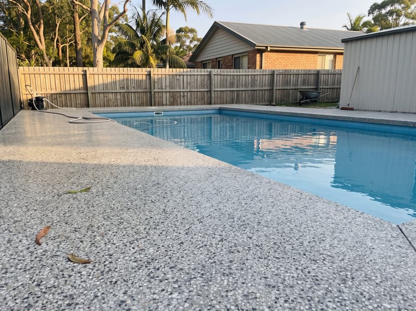 Circular pool with a honed concrete surround and waterfall edge